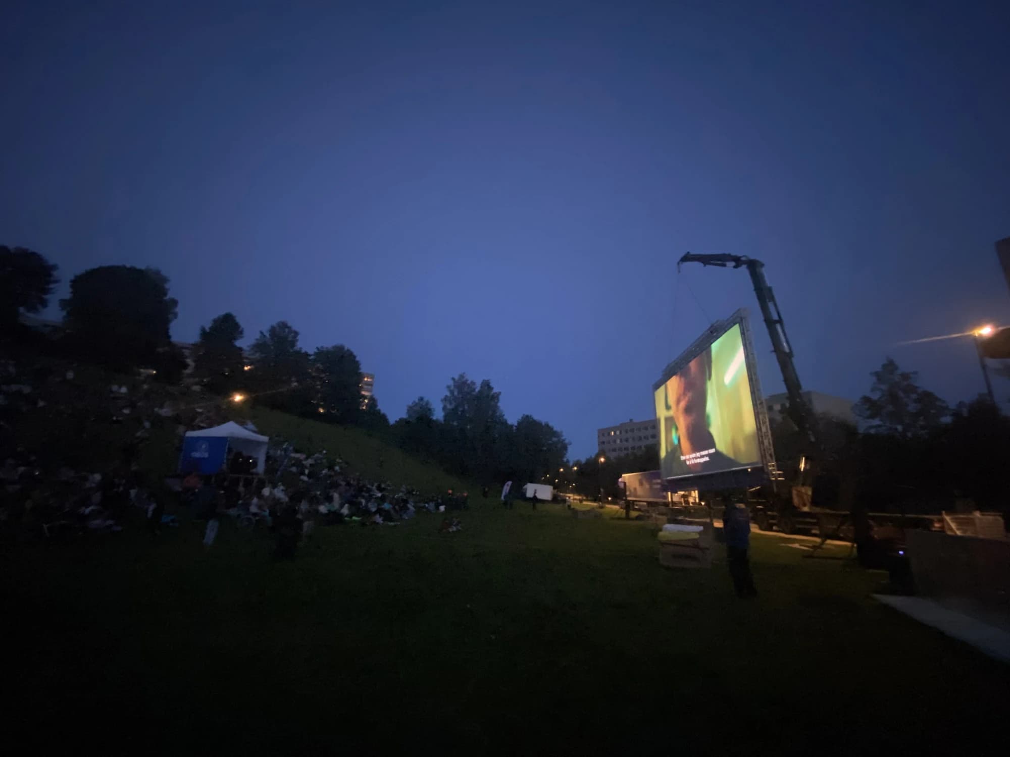 Utekino i skumring — stort lerret heist på plass med kran